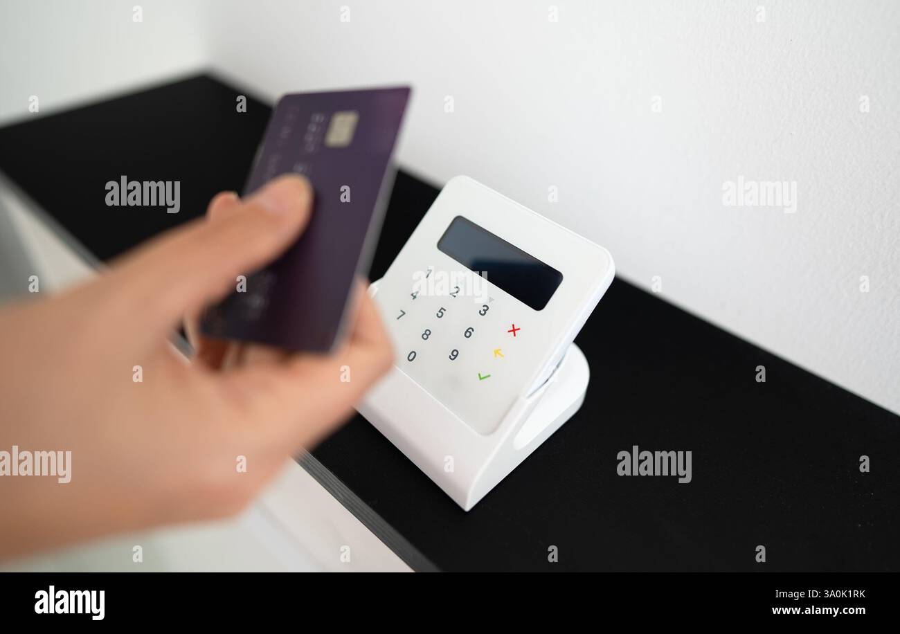 Woman's hand making a contactless payment with a card on a wireless ...