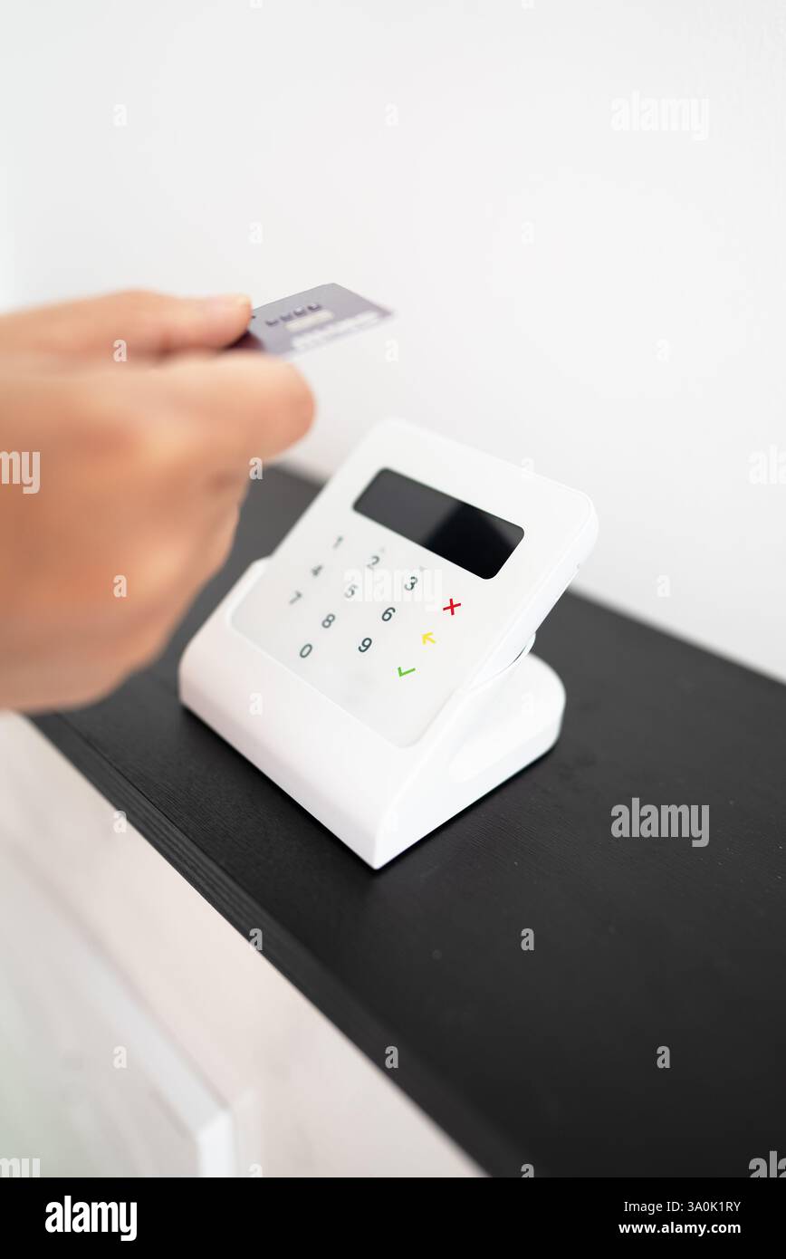 Woman's hand making a contactless payment with a card on a wireless ...