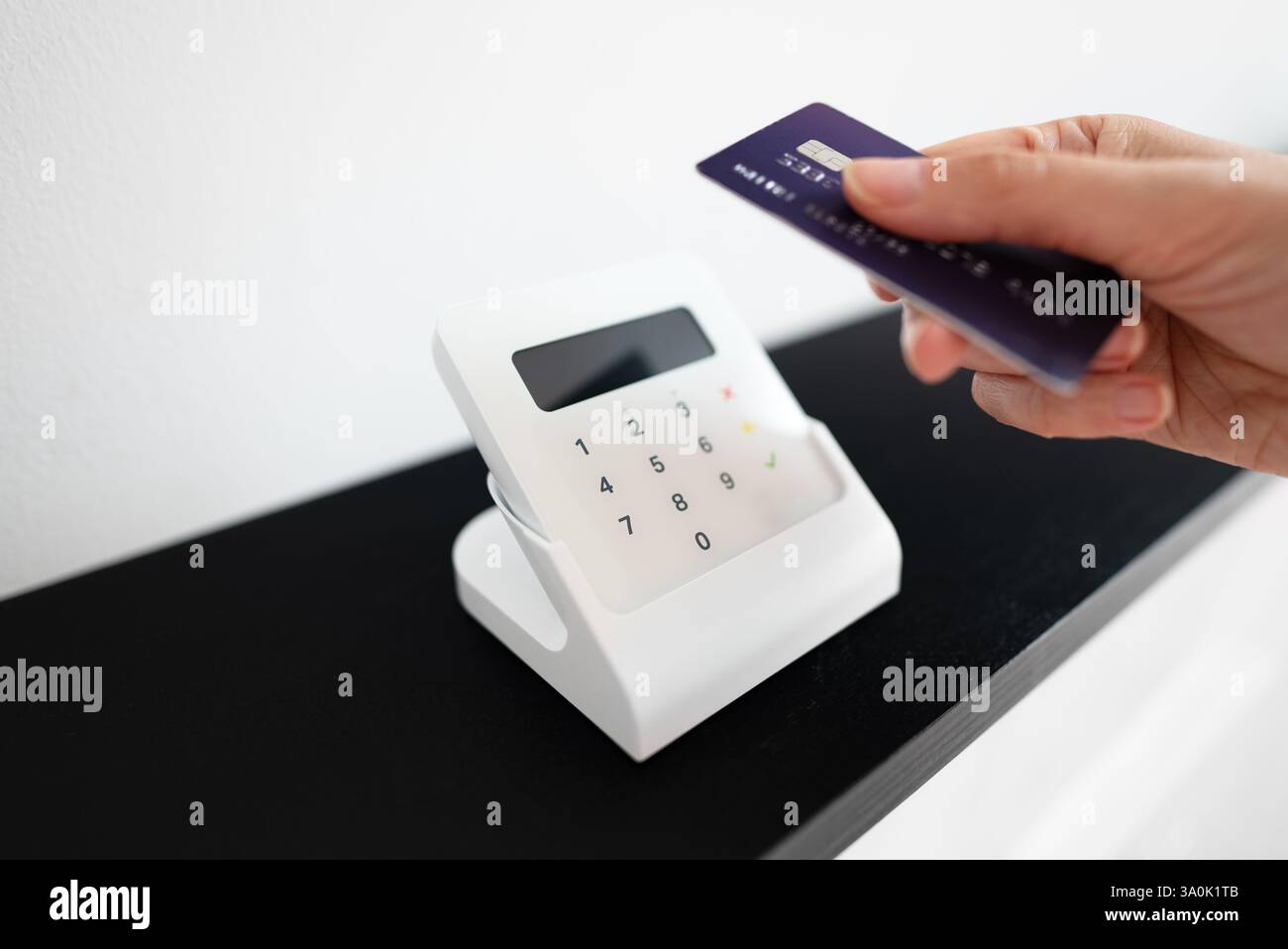 Woman's hand making a contactless payment with a card on a wireless ...