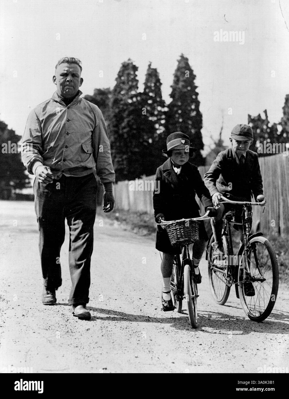 Does it mean a 'come back' ?, Joe keeps in training -- Joe Beckett on the road near Southampton paced by his daughter Margaret and son Joe junior. The famous boxer keeps in constant training and his children accompany him on his daily morning road-work. April 10, 1933. (Photo by London News Agency Photos). Stock Photo