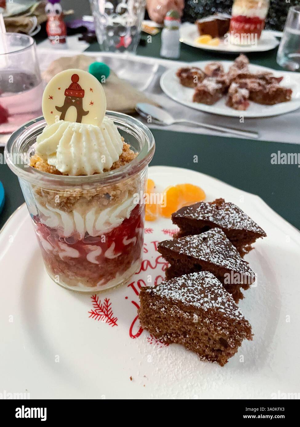 Dessert im Gläschen mit Sahne, Beerenmousse und Hafercrunch, auf einem Teller mit Gewürzkuchen in Tannenbaum Form serviert Stock Photo
