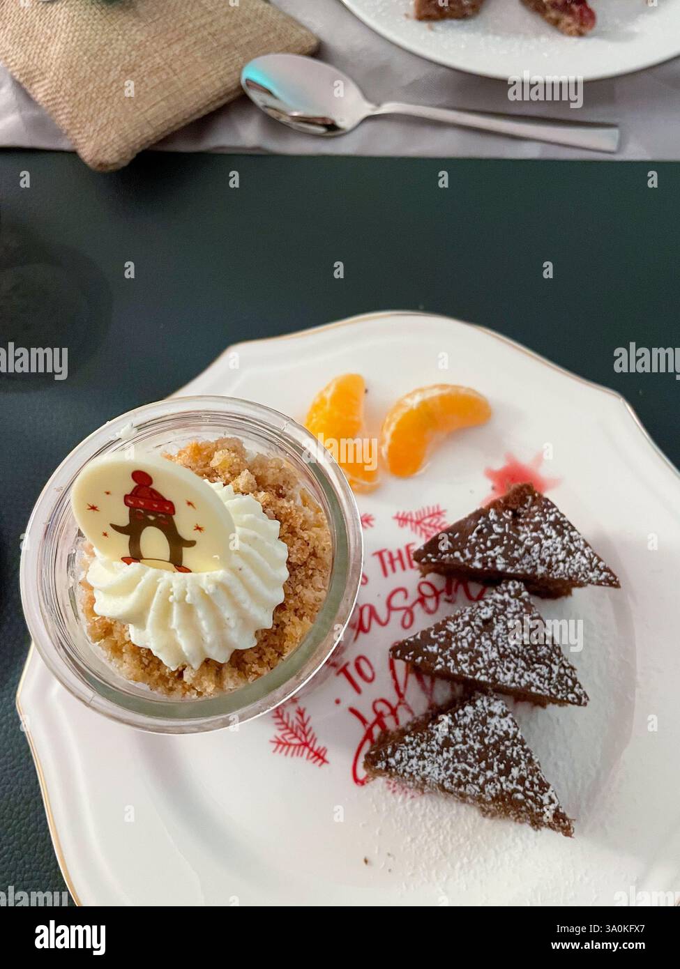 Dessert im Gläschen mit Sahne, Beerenmousse und Hafercrunch, auf einem Teller mit Gewürzkuchen in Tannenbaum Form serviert Stock Photo