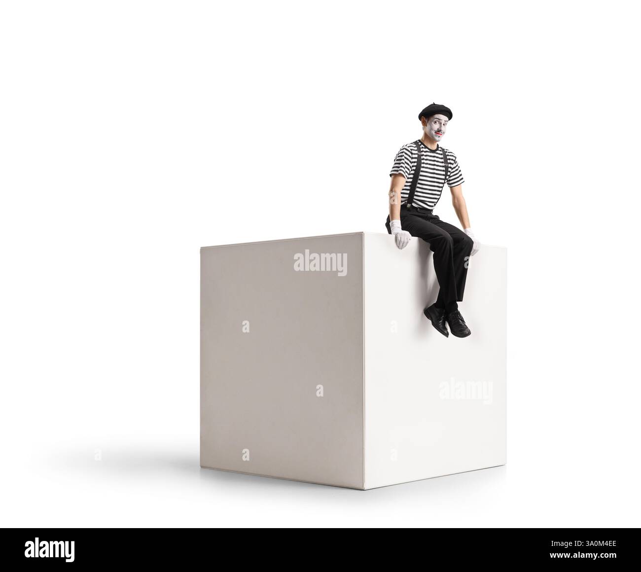 Mime sitting on a white cube isolated on white background Stock Photo
