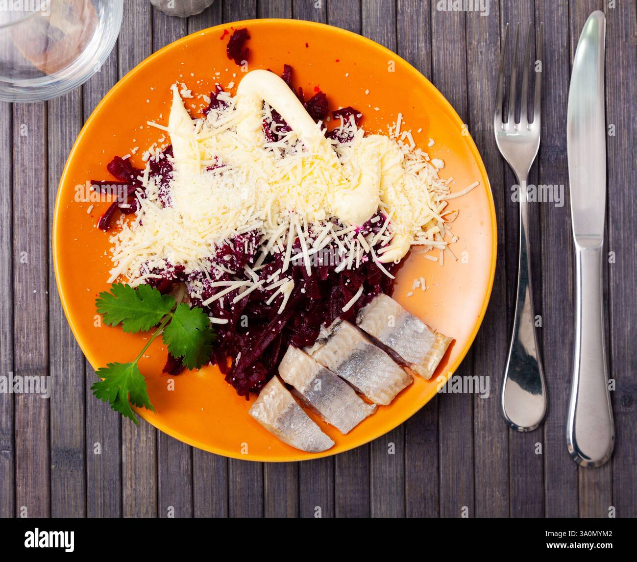 Sliced herring with grated beetroot and cheese served on table Stock Photo