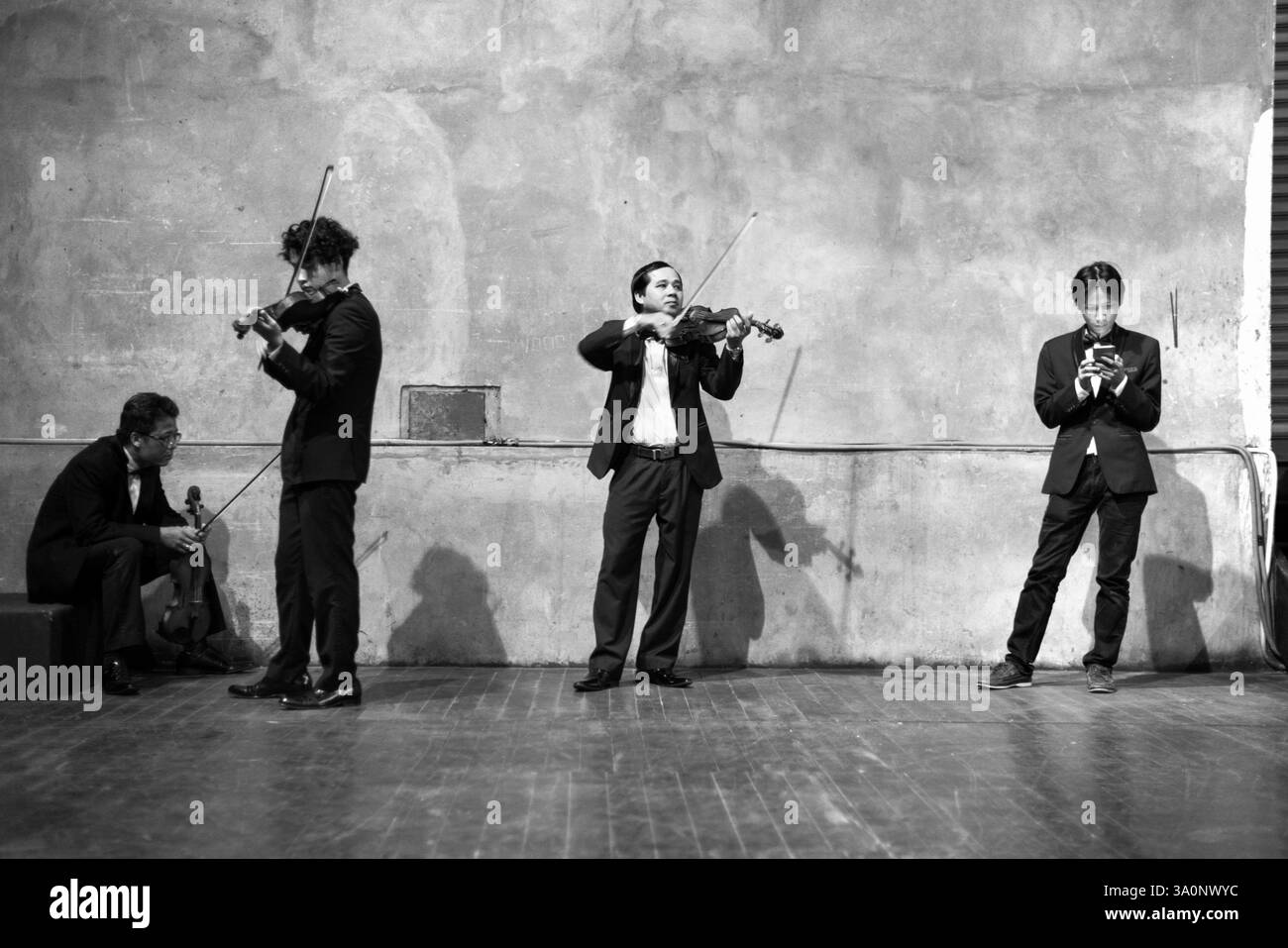 Members of the Vietnam National Symphony Orchestra warm up back stage before a performance at the national opera house in Hanoi on 26 Oct. 2017. ROB G Stock Photo