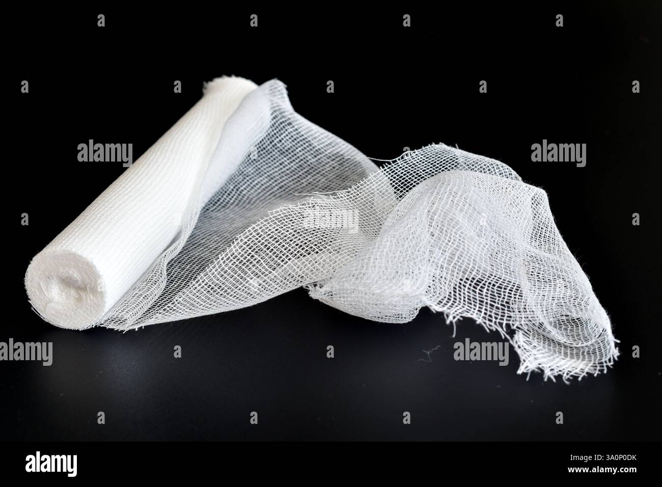 A roll of gauze bandage lies on a black background Stock Photo - Alamy