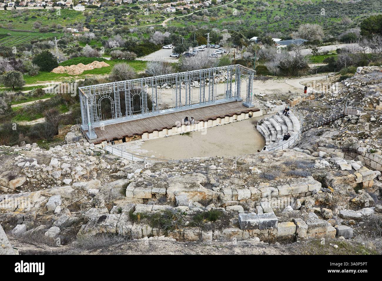 An ancient amphitheater with stone seating and a modern stage structure ...