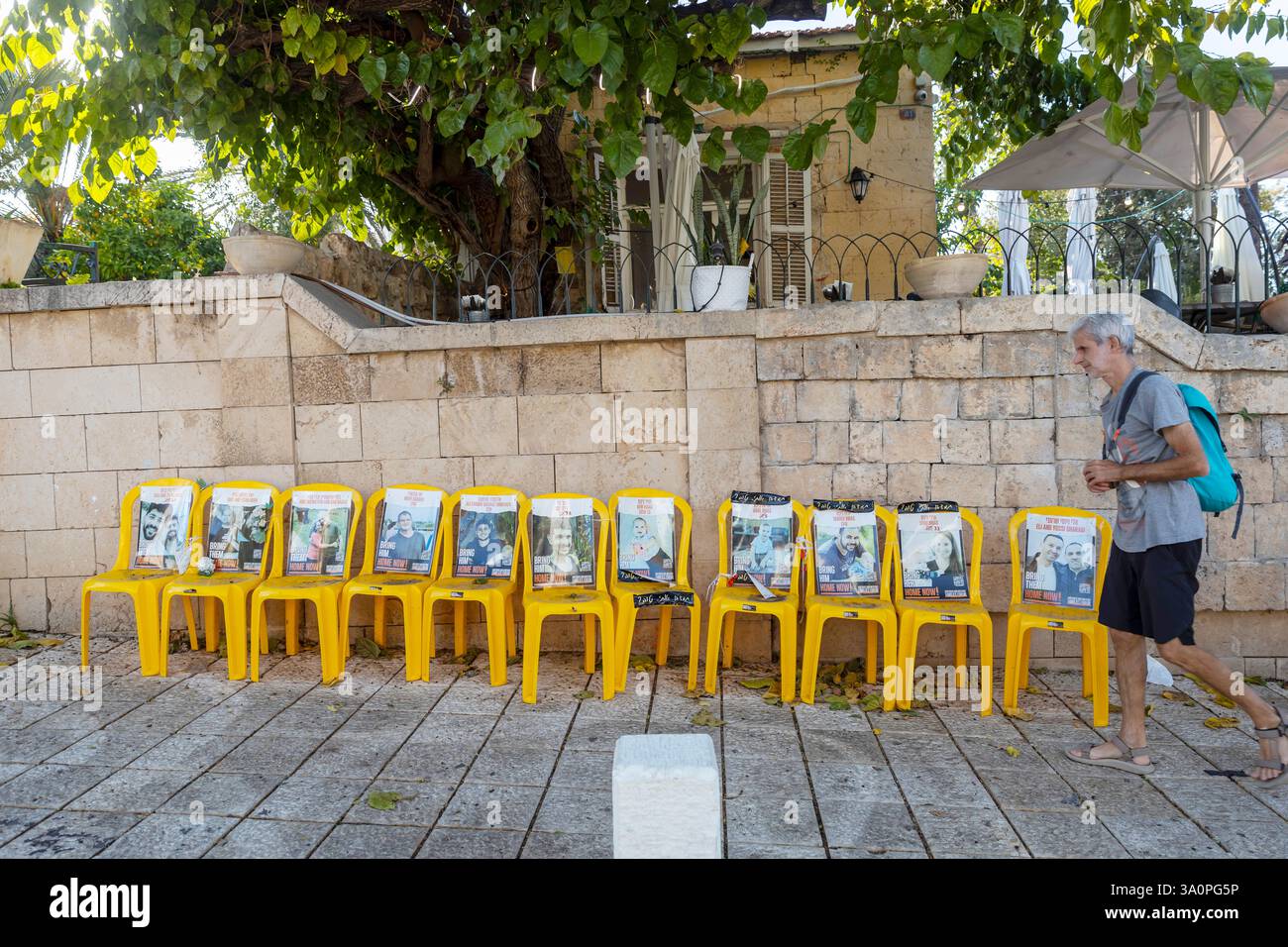 Zikhron Ya'akov, Israel - October 20, 2024, yellow chairs with photographs of Israeli hostages taken by Hamas terrorists on October 7 next to the hous Stock Photo