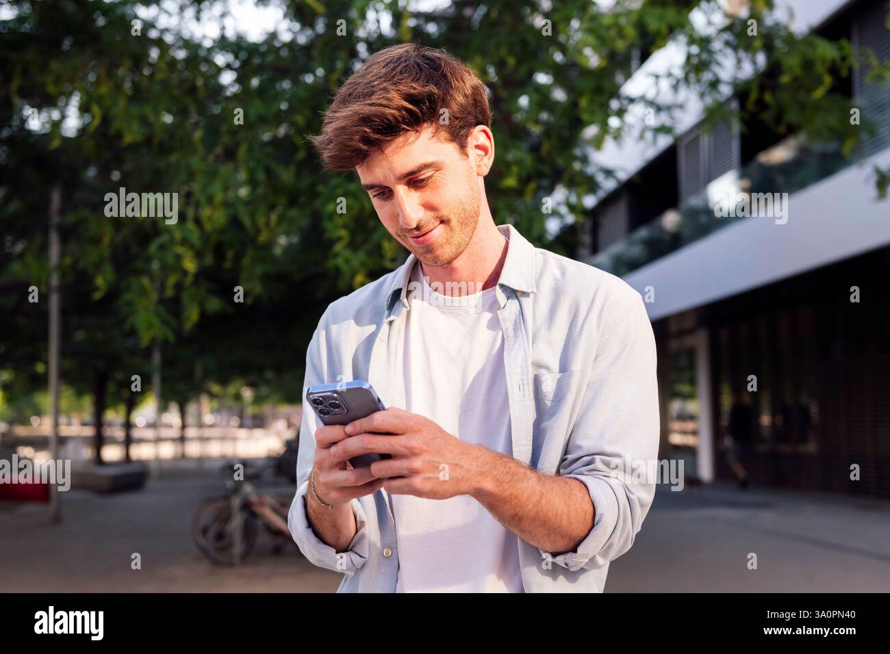 man using cell phone while walking down the street Stock Photo