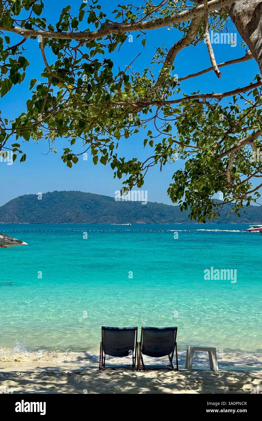 Turquoise Waters and Lounge Chairs in a Tropical Paradise 3 Two wooden lounge chairs sit on a pristine sandy beach, offering a breathtaking view of th - Smartphone Captured Stock Image