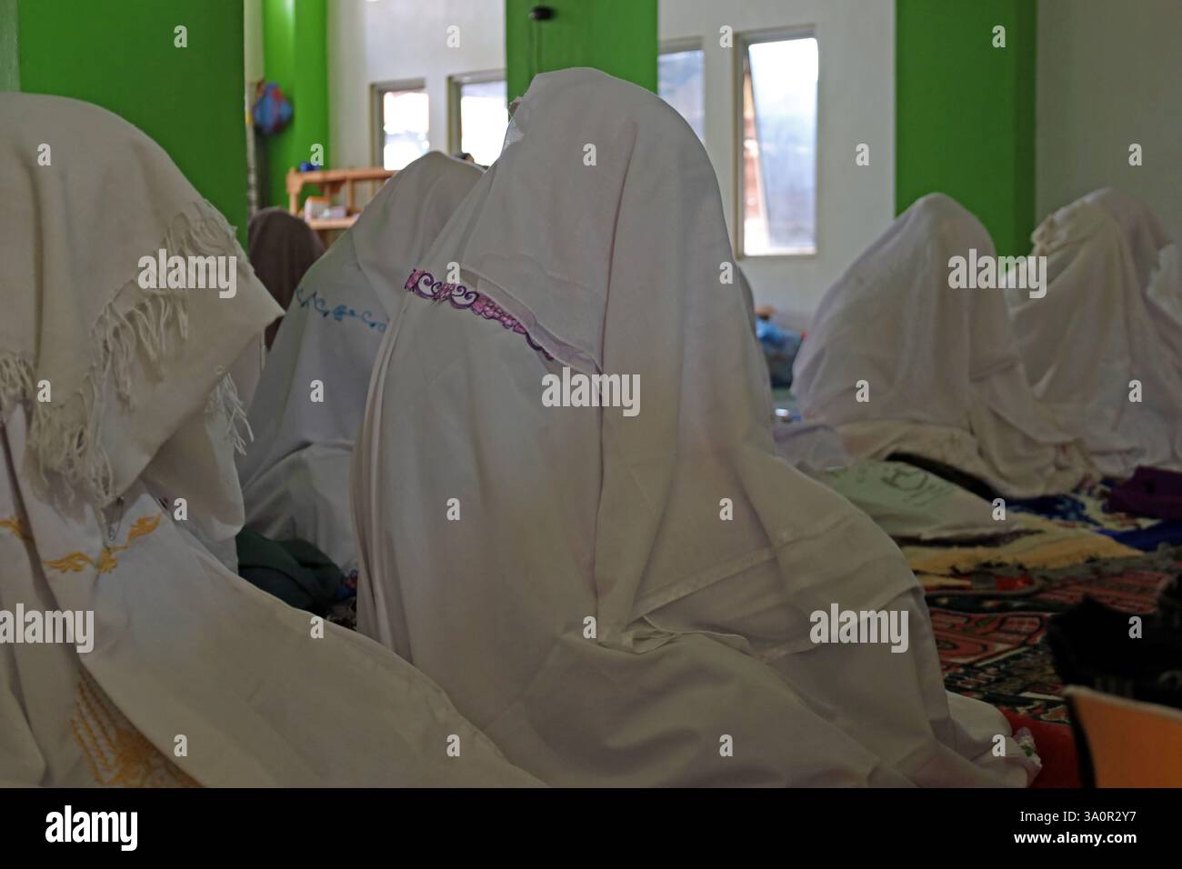 Aceh Besar, Aceh, Indonesia. 5th Mar, 2025. Muslims cover their heads with cloth while attending suluk worship in Dayah Darul Aman, Lampuuk Village, Aceh Besar regency, Aceh province, Indonesia on Wednesday, March 05, 2025. Suluk spiritual activities for Muslims in Aceh have become a tradition in the month of Ramadan which is followed by male and female pilgrims with dhikr, sunnah prayers, and other worship that aims to purify the heart, purify the soul and get closer to Allah SWT. Credit: Khairu Syukrillah/ZUMA Press Wire/ZUMA Wire/Alamy Live News Stock Photo