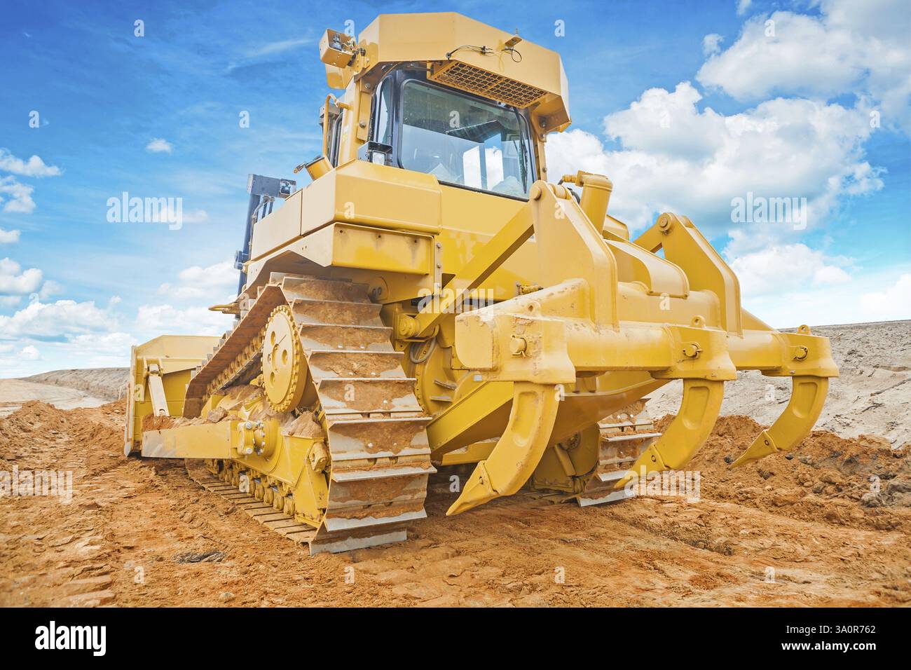 Bulldozer yellow coloured standing on sand rear view Stock Photo - Alamy