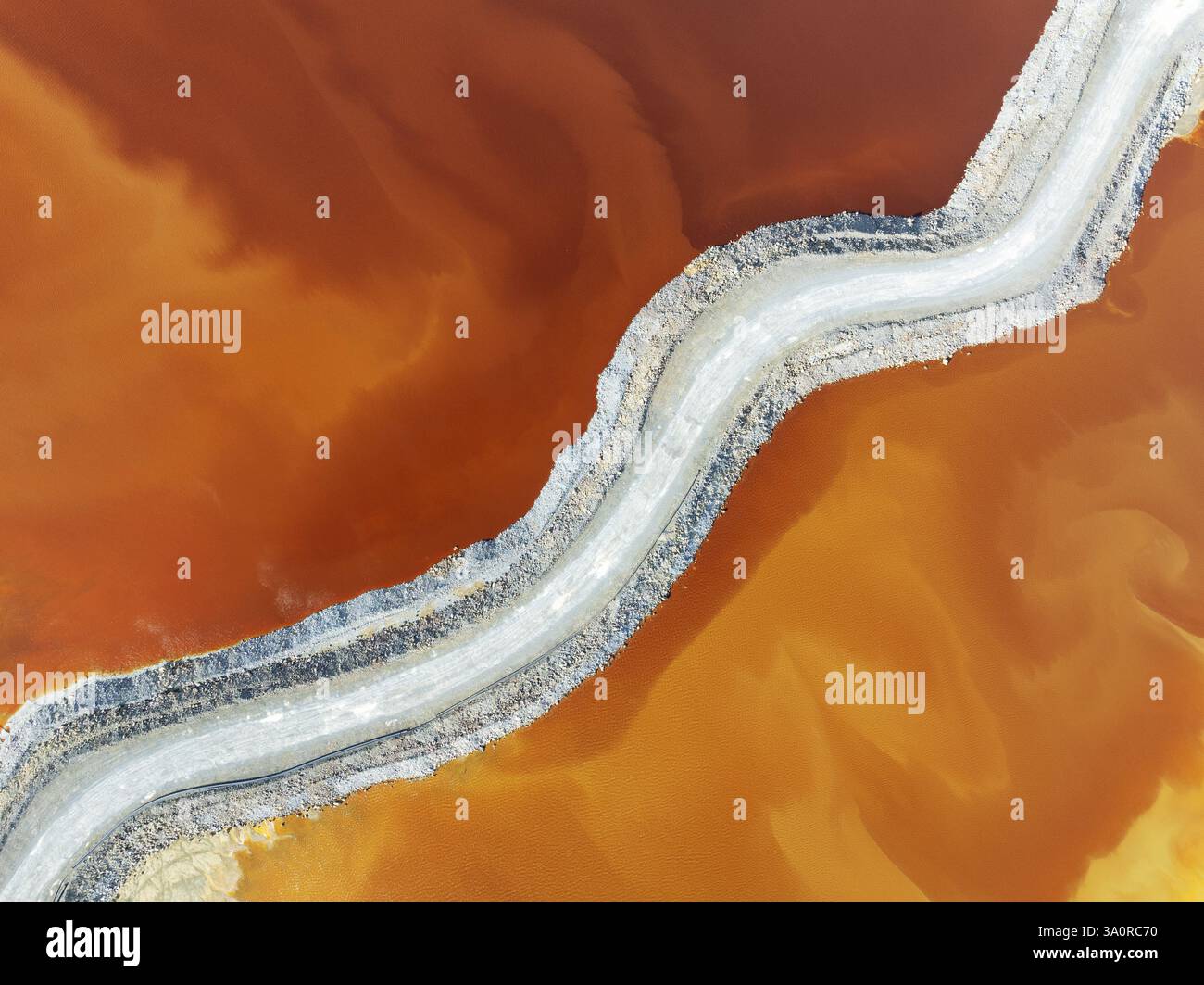 Track crossing a waste pond in the mineral-rich area of the Rio Tinto ...