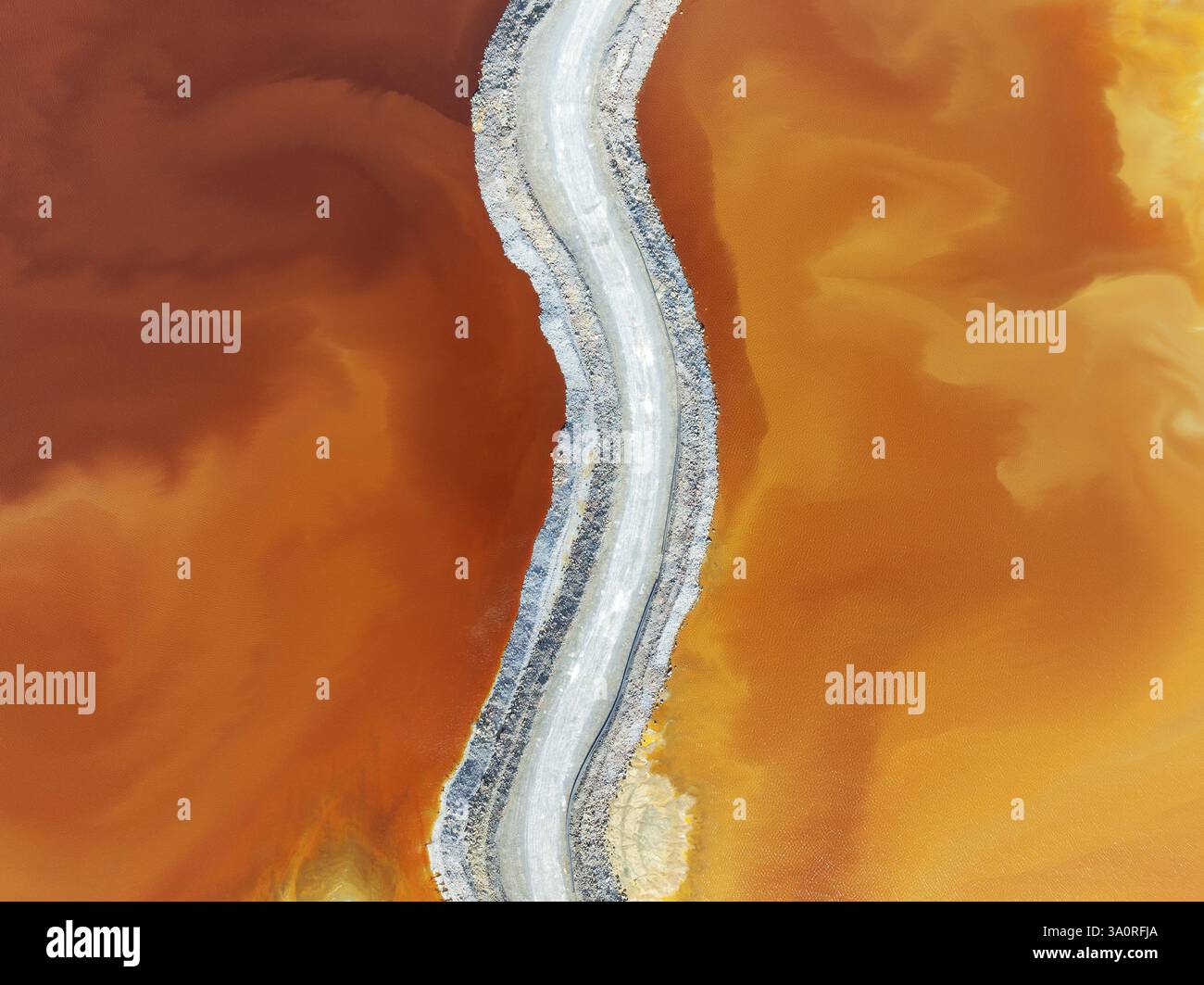 Track crossing a waste pond in the mineral-rich area of the Rio Tinto ...