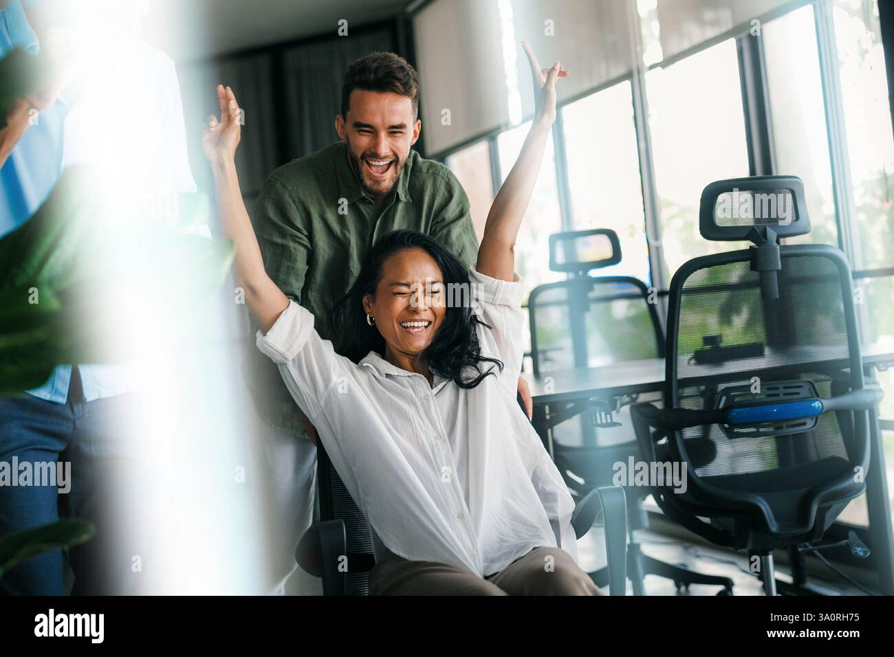 Excited diverse employees laughing enjoying funny activity at work break, creative friendly workers Stock Photo