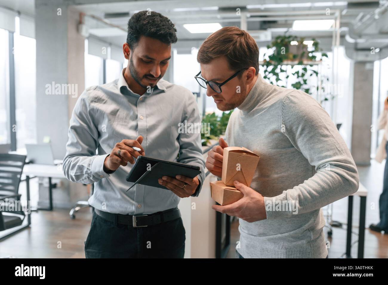 Two men are working in the modern office together. Stock Photo