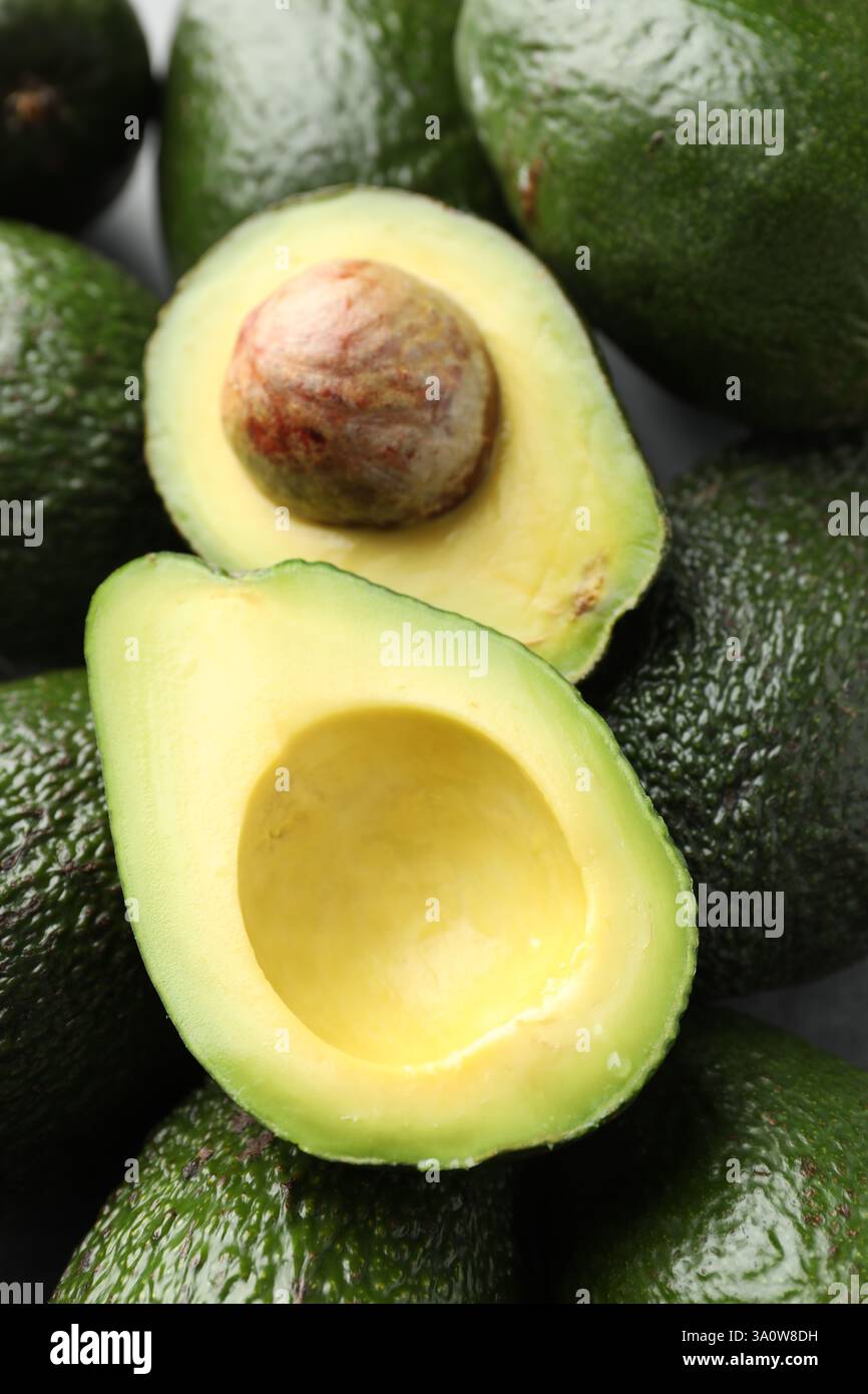 Many whole and cut avocados on table, above view Stock Photo - Alamy