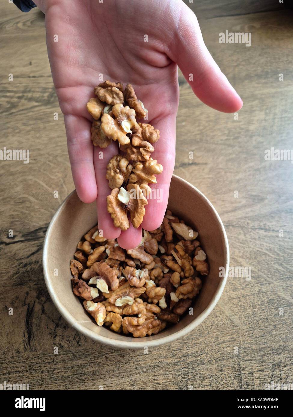 walnuts in hand and in a box - Smartphone Captured Stock Image