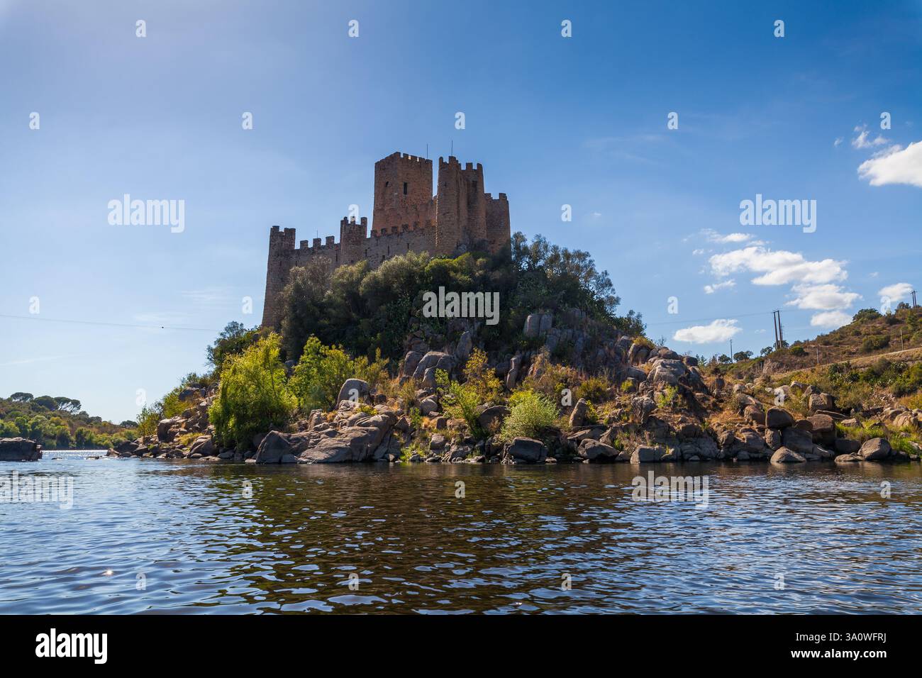 A historic castle stands majestically atop a rocky island surrounded by ...
