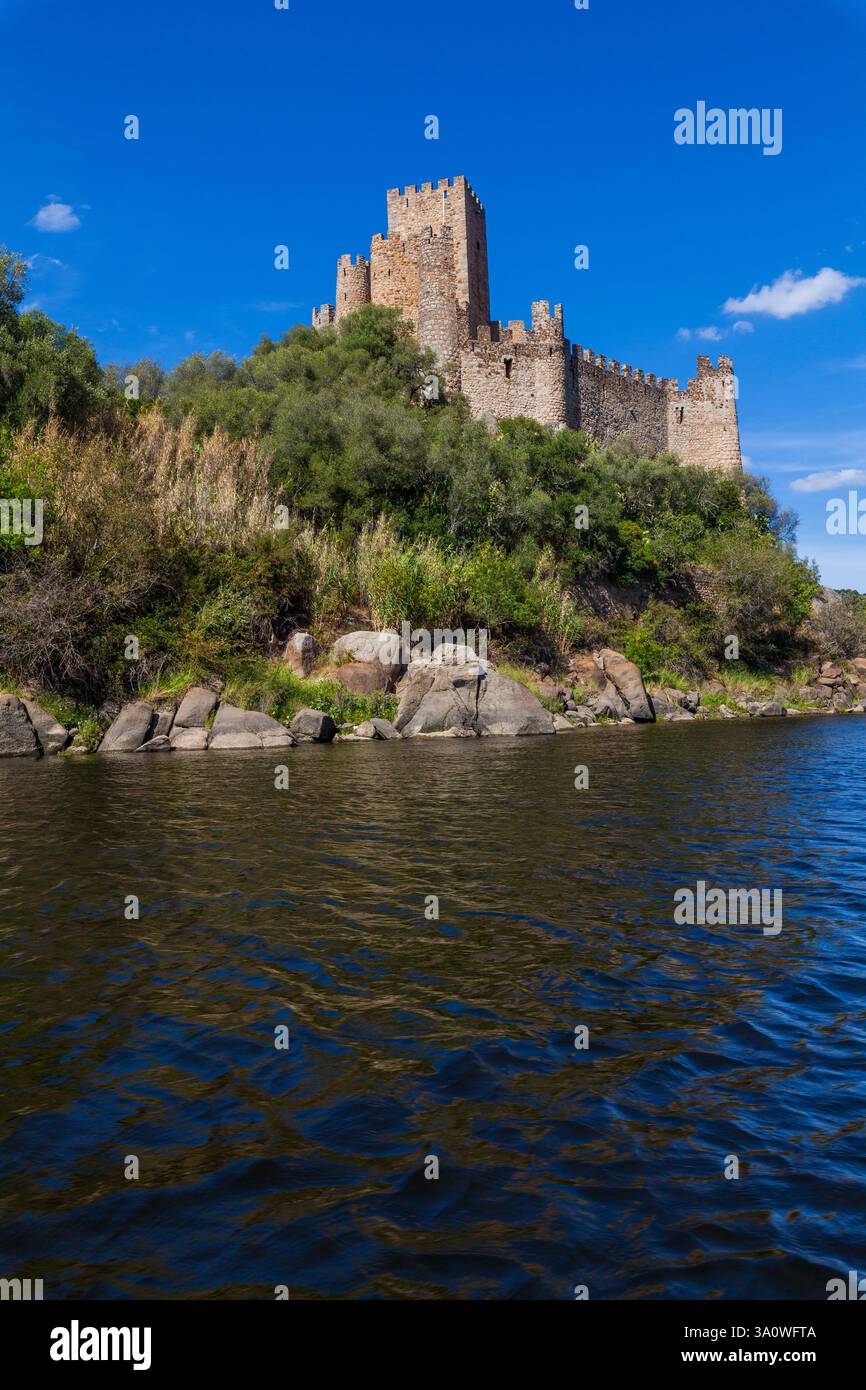 A historic castle stands majestically atop a rocky island surrounded by ...