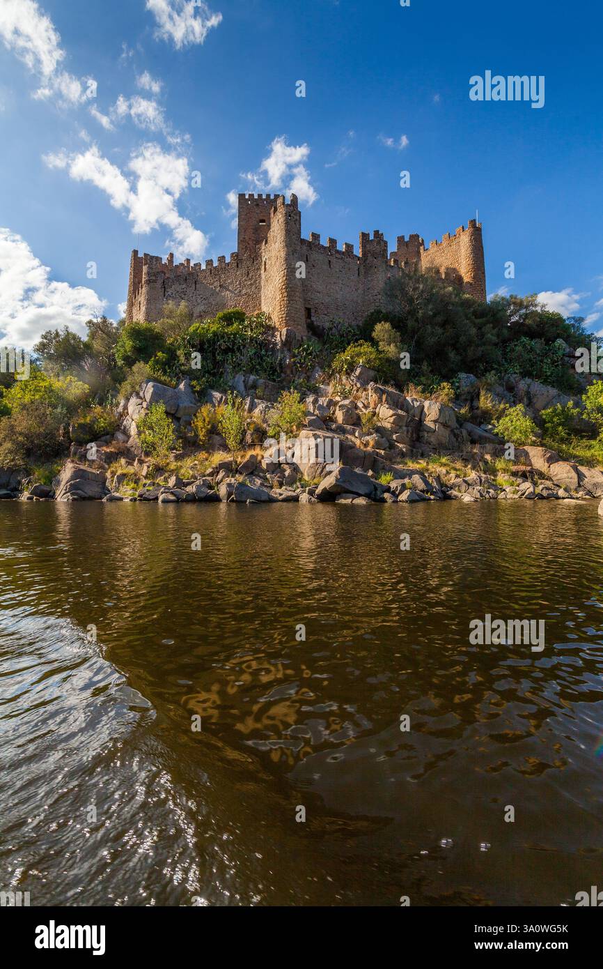 A historic castle stands majestically atop a rocky island surrounded by ...