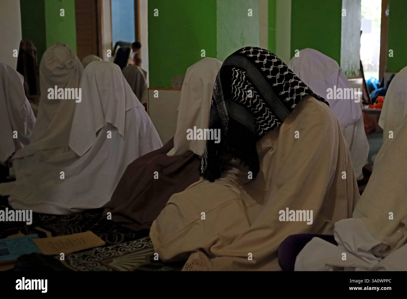 Aceh Besar, Aceh, Indonesia. 5th Mar, 2025. Muslims cover their heads with cloth while attending suluk worship in Dayah Darul Aman, Lampuuk Village, Aceh Besar regency, Aceh province, Indonesia on Wednesday, March 05, 2025. Suluk spiritual activities for Muslims in Aceh have become a tradition in the month of Ramadan which is followed by male and female pilgrims with dhikr, sunnah prayers, and other worship that aims to purify the heart, purify the soul and get closer to Allah SWT. Credit: Khairu Syukrillah/ZUMA Press Wire/ZUMA Wire/Alamy Live News Stock Photo