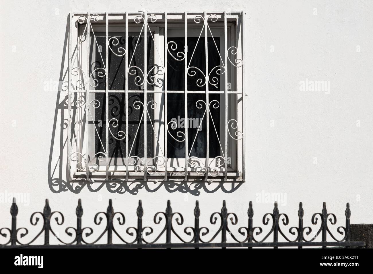 White facade with window and wrought iron railing. Front view of cozy ...