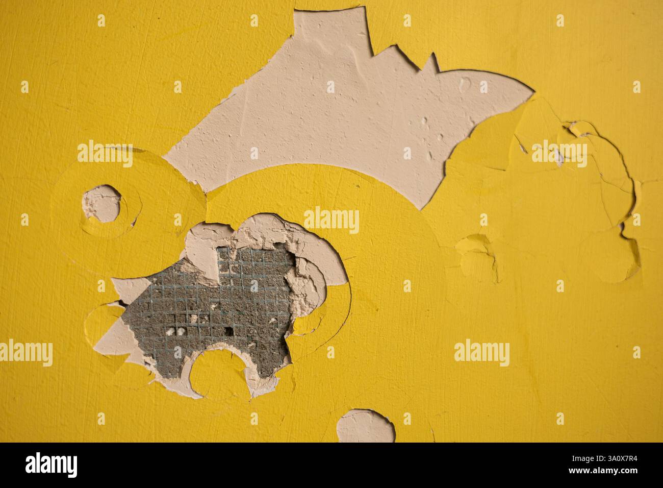 Cracked paint on yellow wall Stock Photo