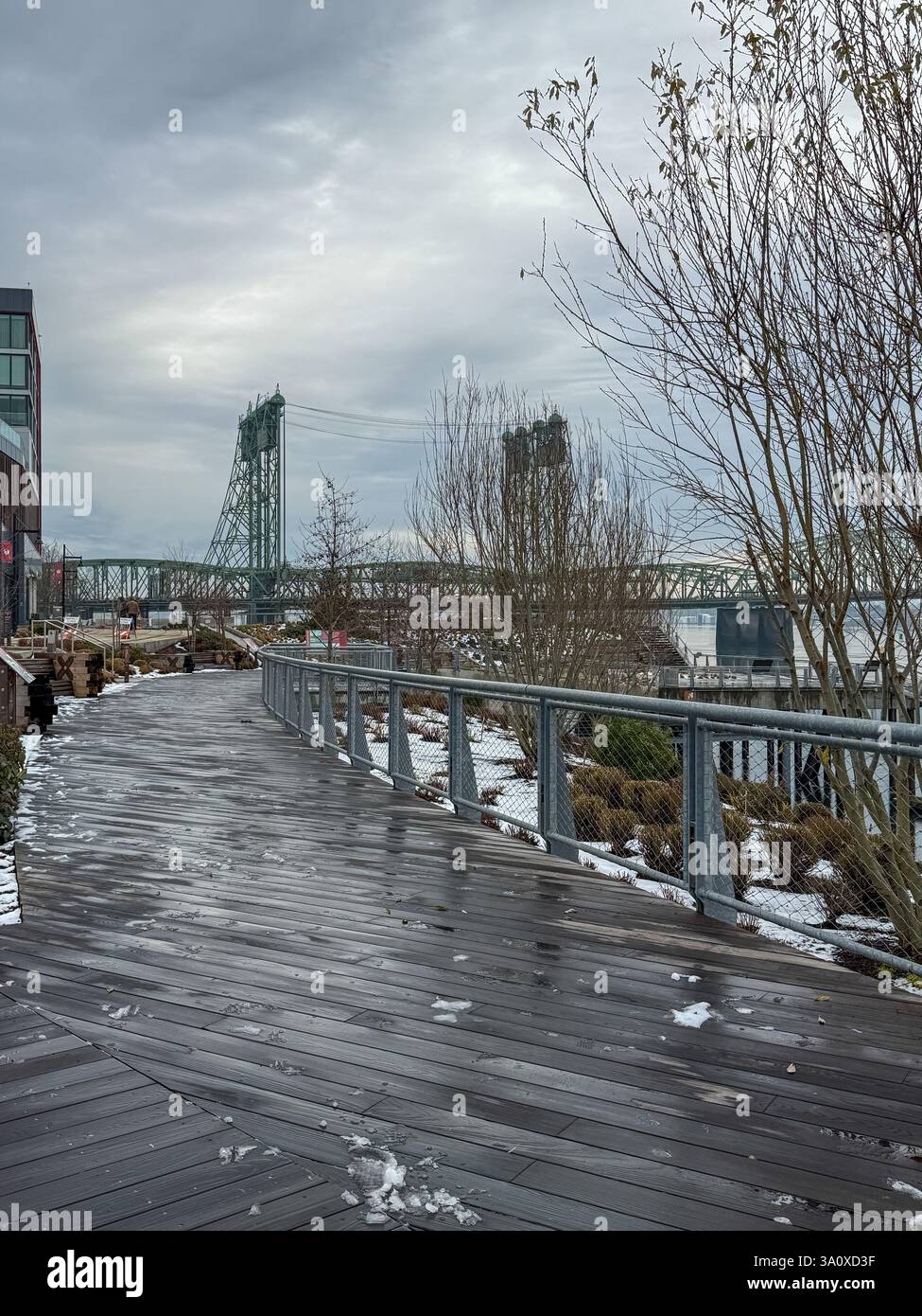 Winter view of the damp, cold and dreary Vancouver Washington boardwalk, as the snow turns to slush. Looking towards a bridge over the Columbia River. - Smartphone Captured Stock Image
