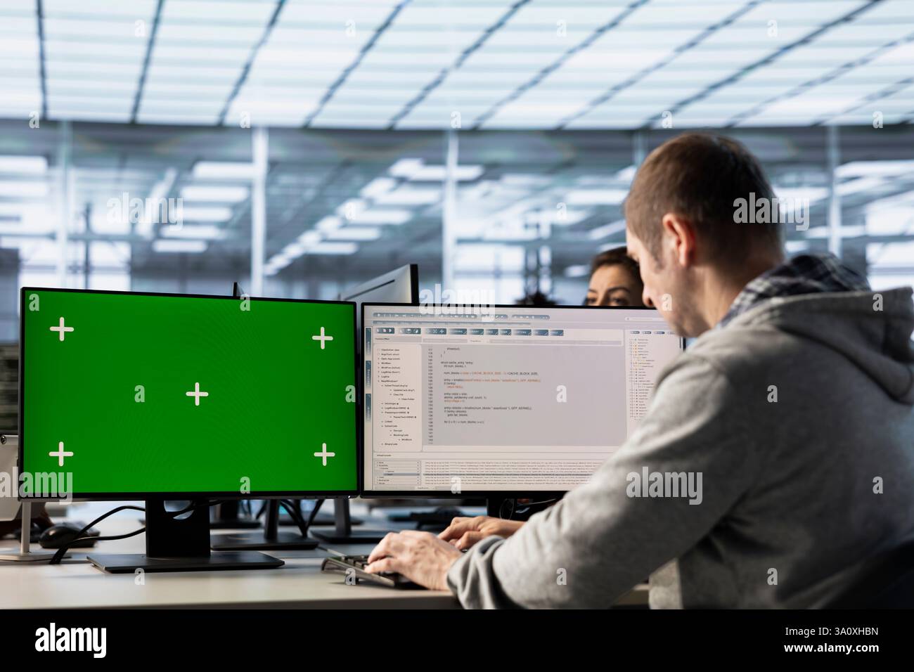 Engineer in server farm using green screen PC to repair equipment storing datasets. IT professional using mockup computer to do debugging on rigs doing computational operations Stock Photo