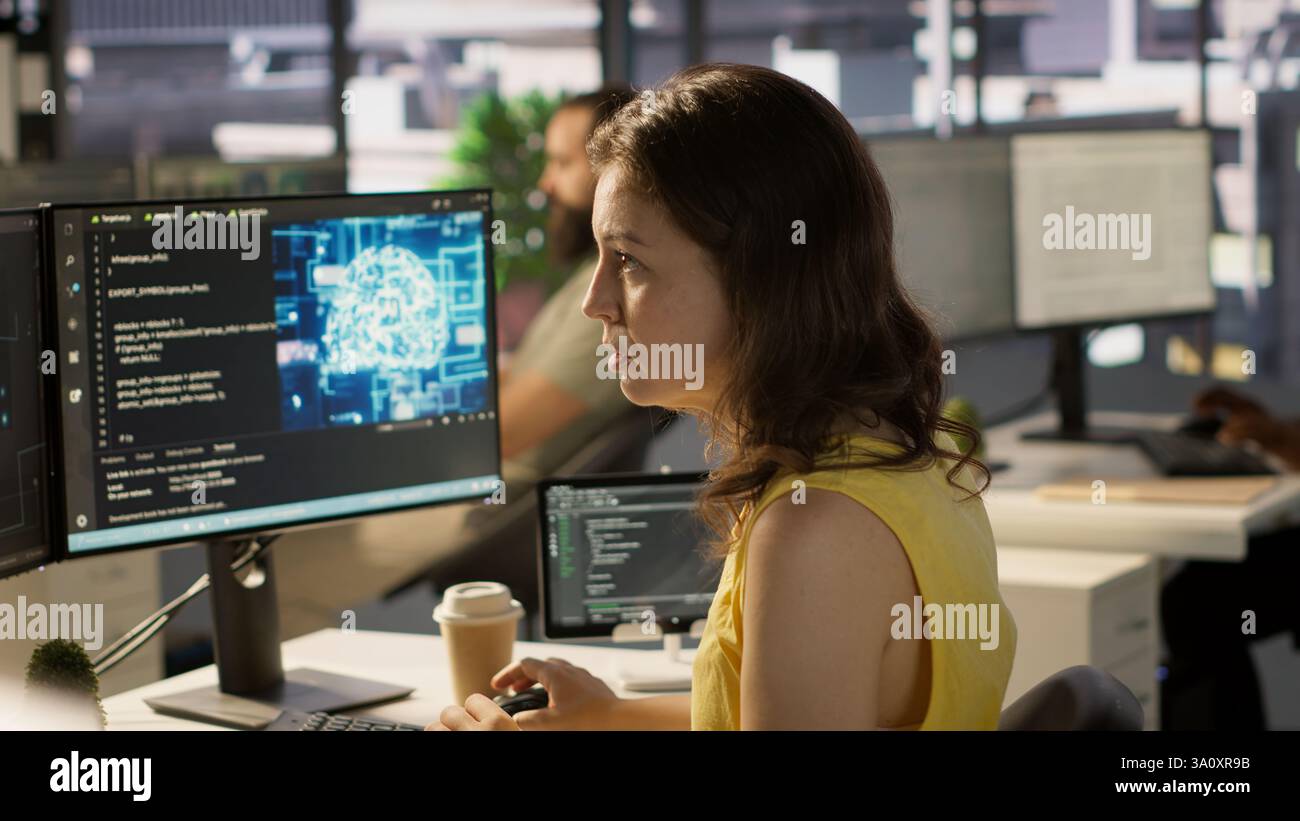System administrator at work doing debugging of AI software using PC, checking glitches in lines of code. IT specialist in office fixing artificial intelligence coding issues using computer, camera A Stock Photo