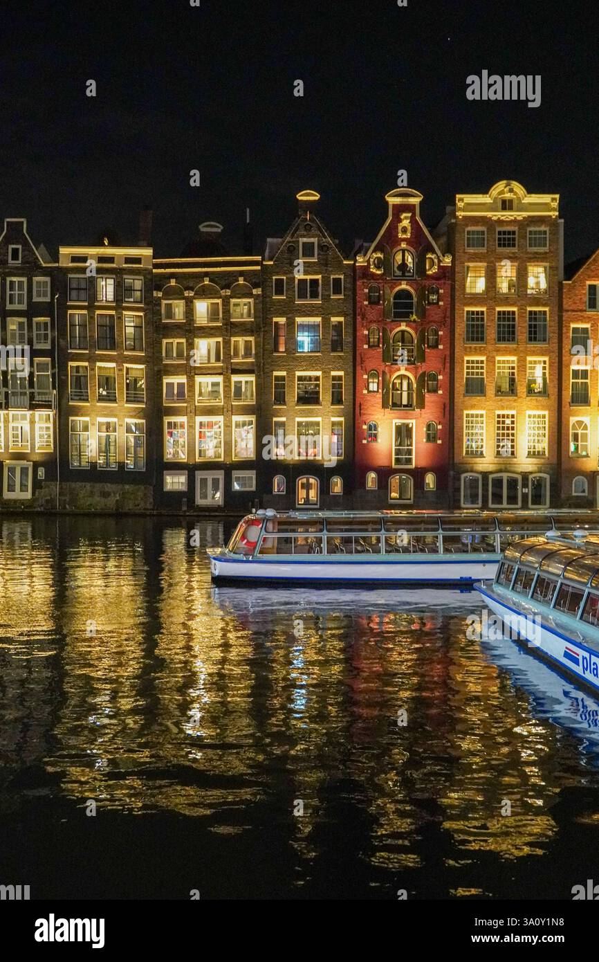 This aerial view of Amsterdam, Netherlands showcases its iconic canal houses, Dutch architecture, and boat tours along the waterfront, capturing the c Stock Photo