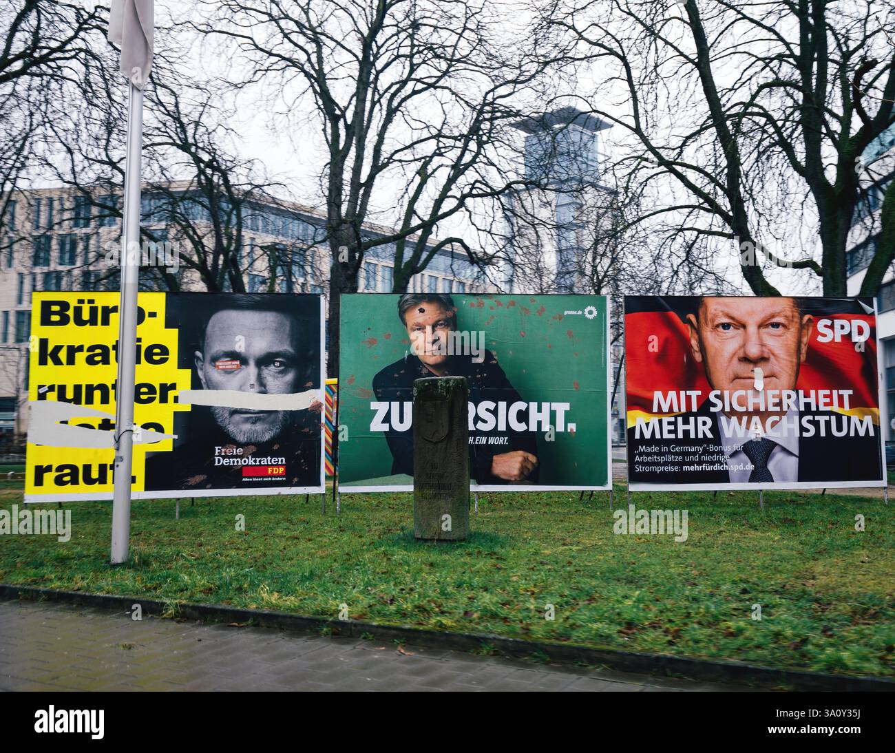 Freiburg, germany - Feb 10, 2025: Three political billboards during a Chancellor election in Germany feature stark, contrasting portraits of candidate Stock Photo