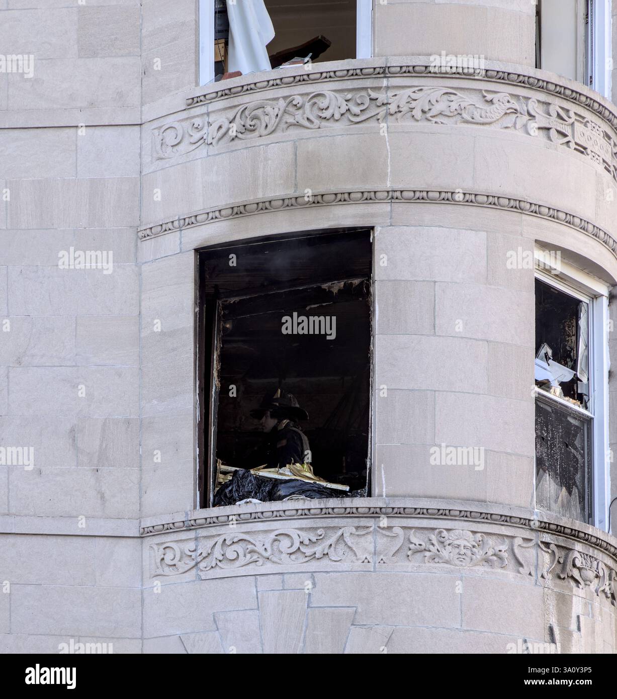 FDNY fire trucks responding to an apartment fire on Bedford Avenue in Brooklyn New York City with ladders into broken windows. Stock Photo