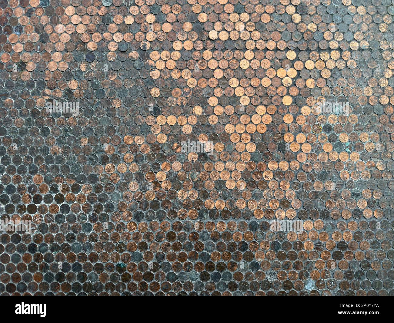 Hundreds of American copper and zinc pennies are shown on display, adhered to a wall. - Smartphone Captured Stock Image