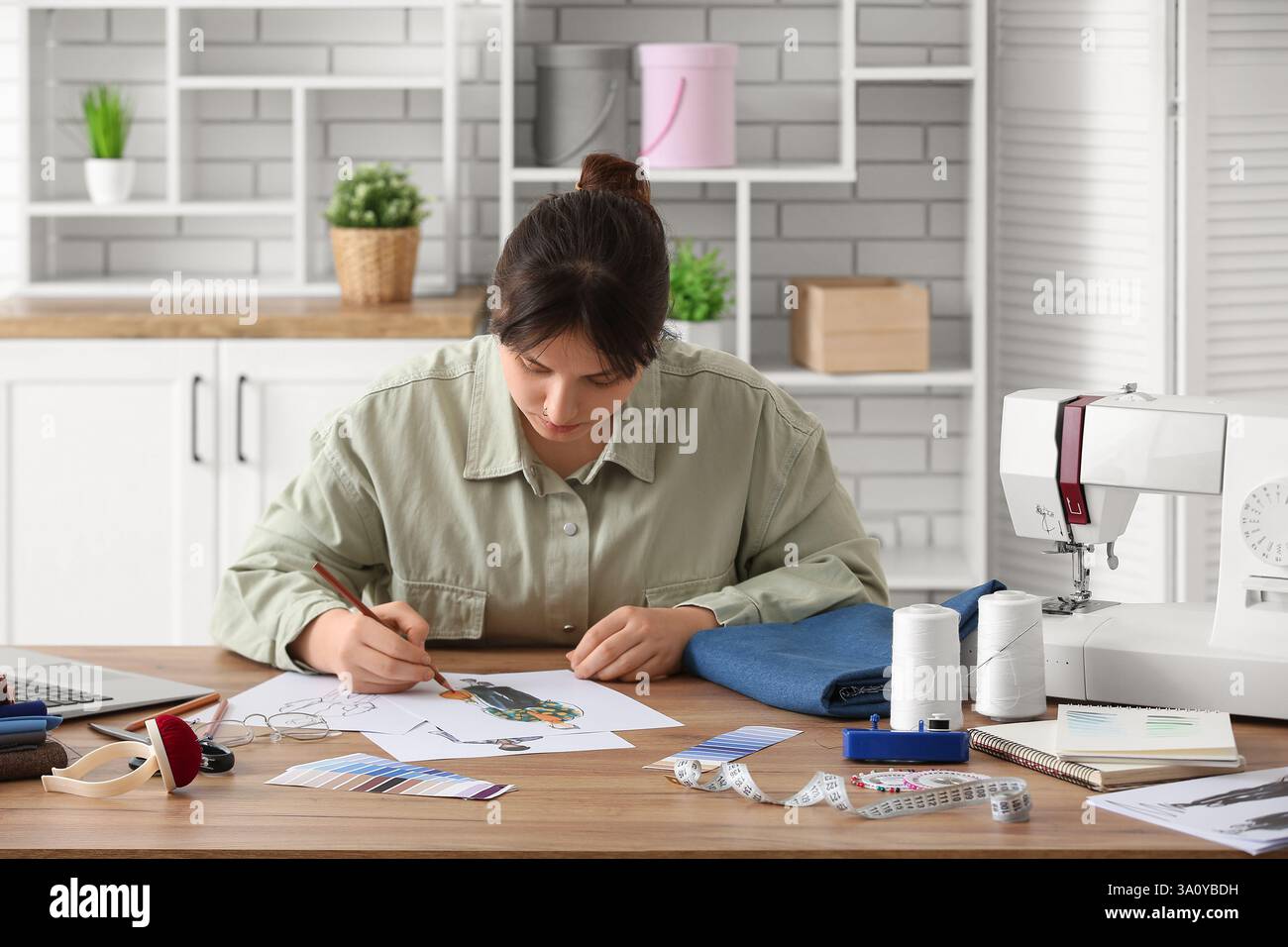 Female fashion designer drawing sketches of male clothing in studio ...