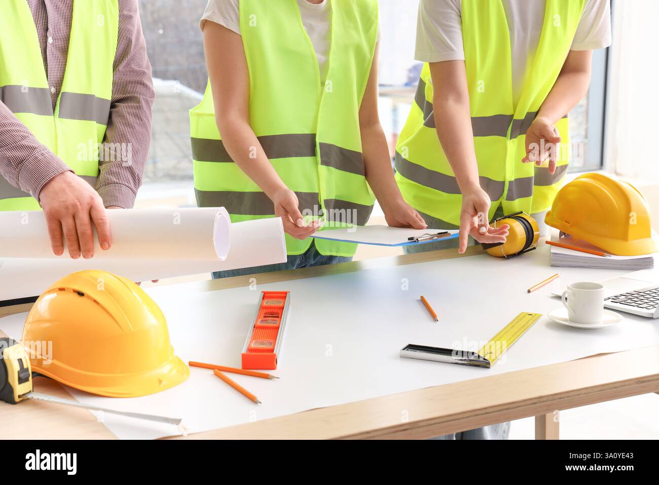 Team of constructors working at table in room Stock Photo