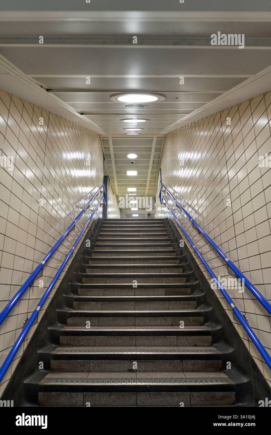 Hand Rails Subway A stairway in a subway station with tiled walls and blue handrails ...