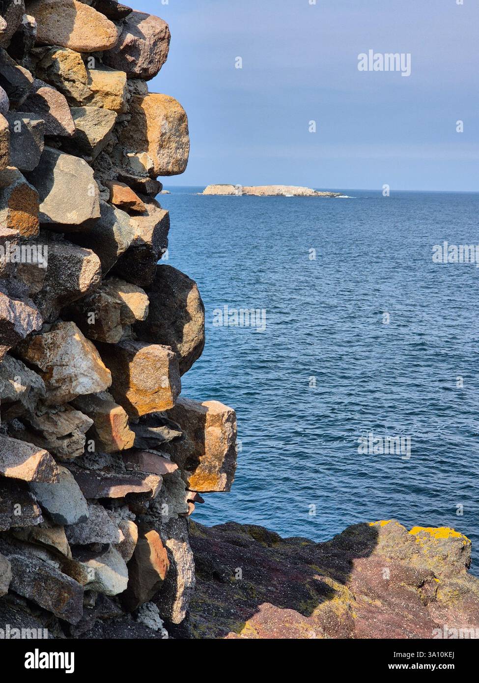 Where the rocks meet the sea. unusual stone wall near the sea - Smartphone Captured Stock Image