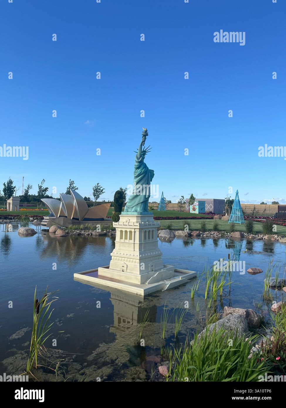 The Statue of Liberty stands proudly in the foreground, with other significant world landmarks visible in the background. - Smartphone Captured Stock Image