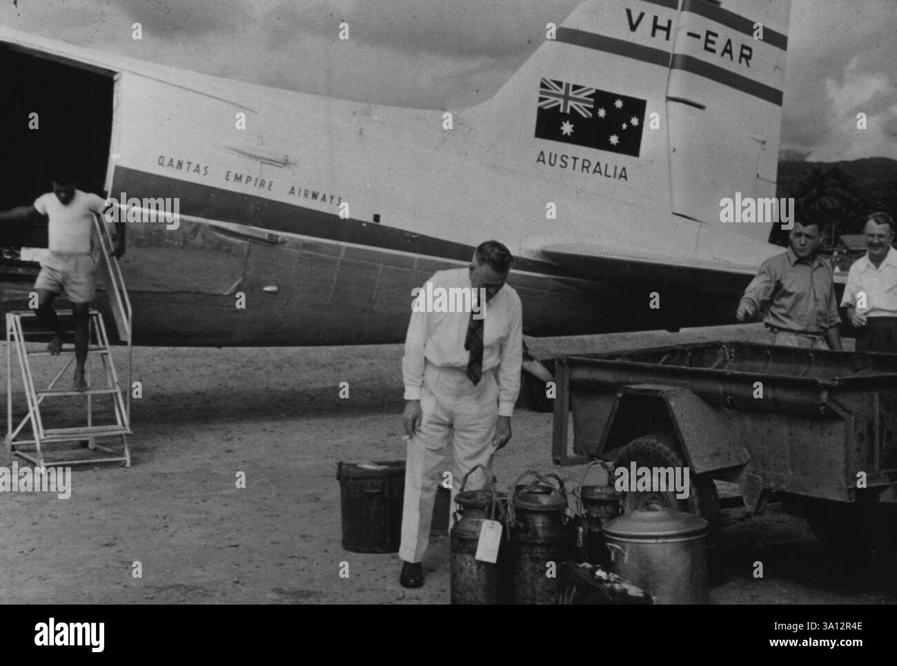 Qantas N.G. manager Orm Denny, with cans of fingerlings at Bulolo airport.Cool, trout-filled mountain streams just don't seem right in the jungles of tropical New Guinea. April 14, 1955. Stock Photo