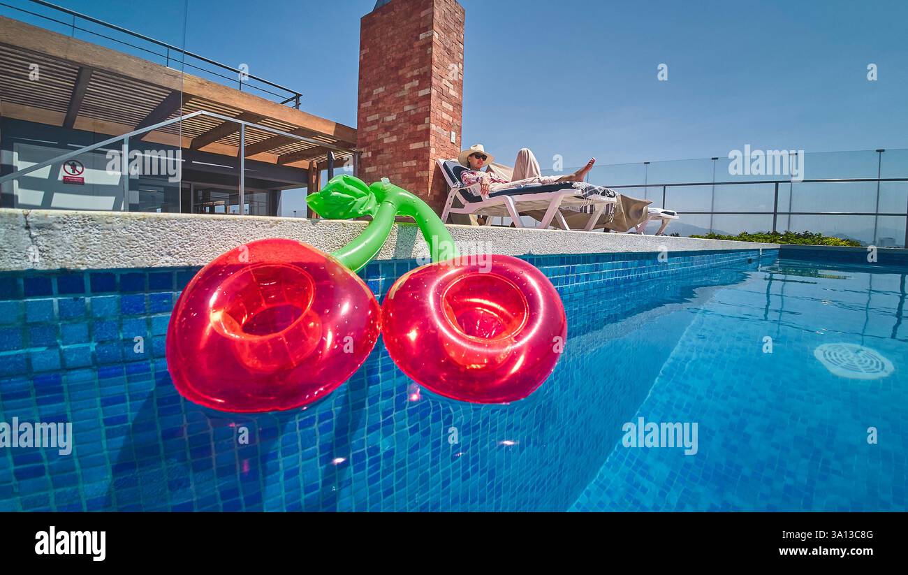 Inflatable cherries floating in a luxurious swimming pool with a ...