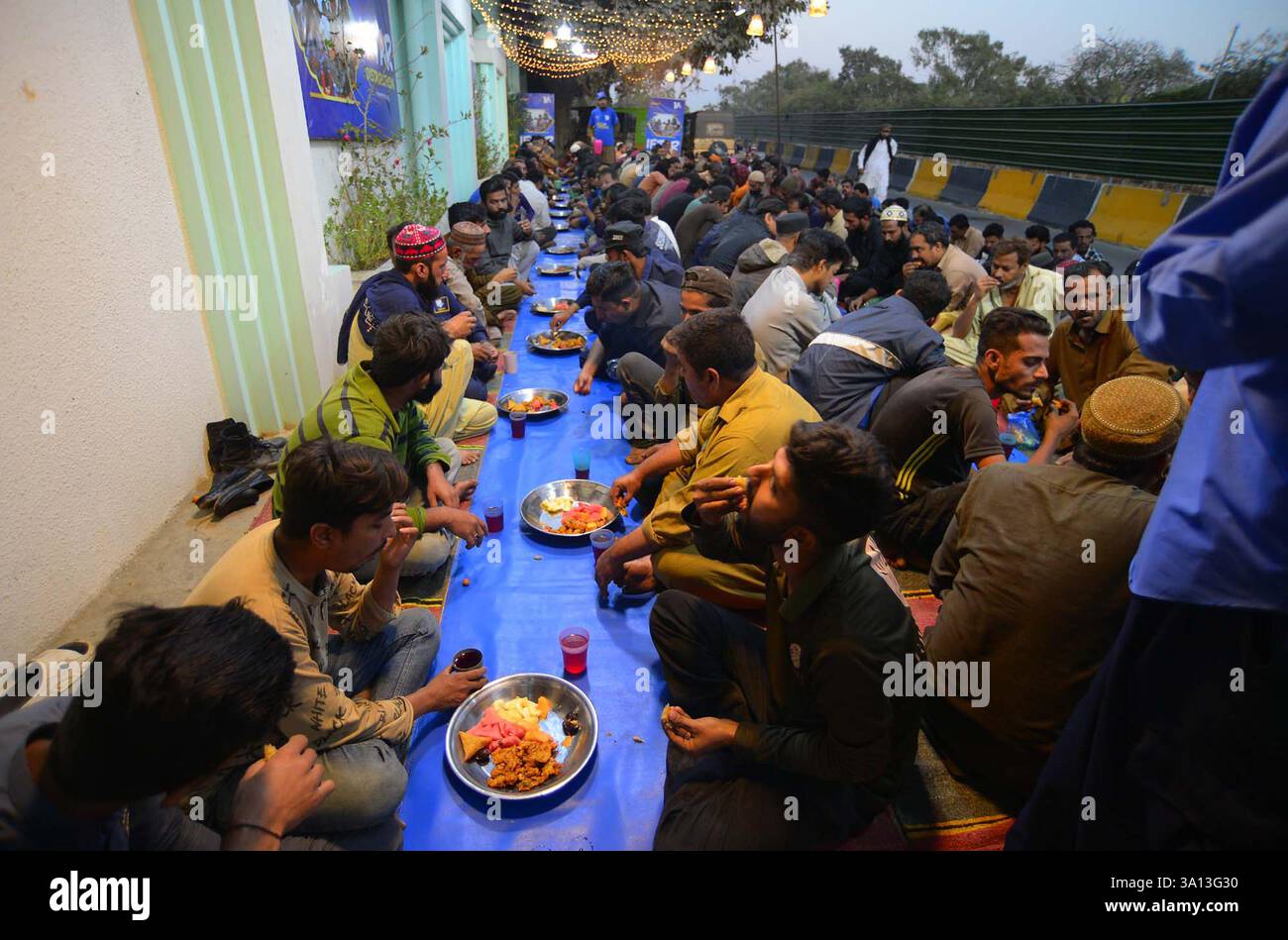 Faithful Muslims are breaking the fast (Iftar) under the supervision of ...