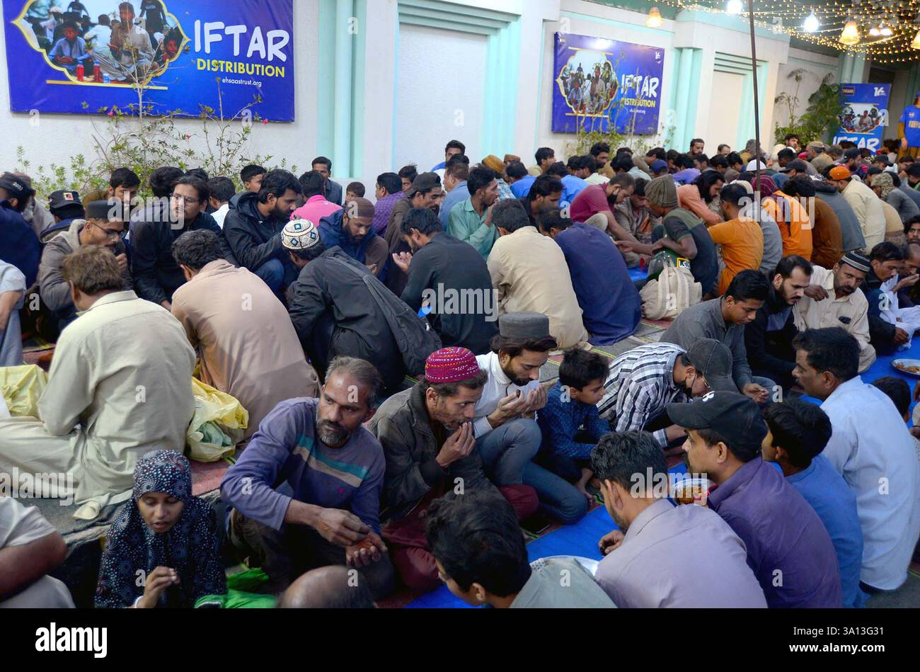 Faithful Muslims are breaking the fast (Iftar) under the supervision of ...