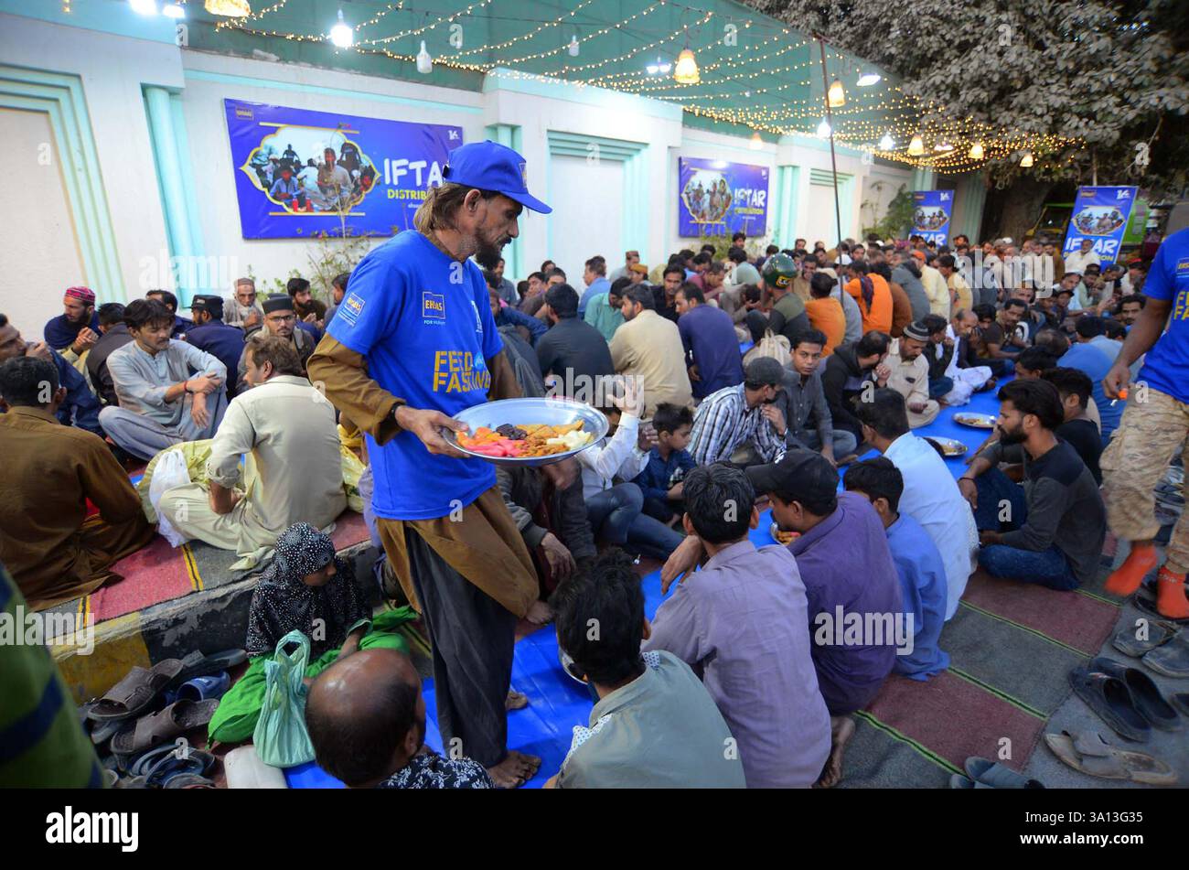 Faithful Muslims are breaking the fast (Iftar) under the supervision of ...
