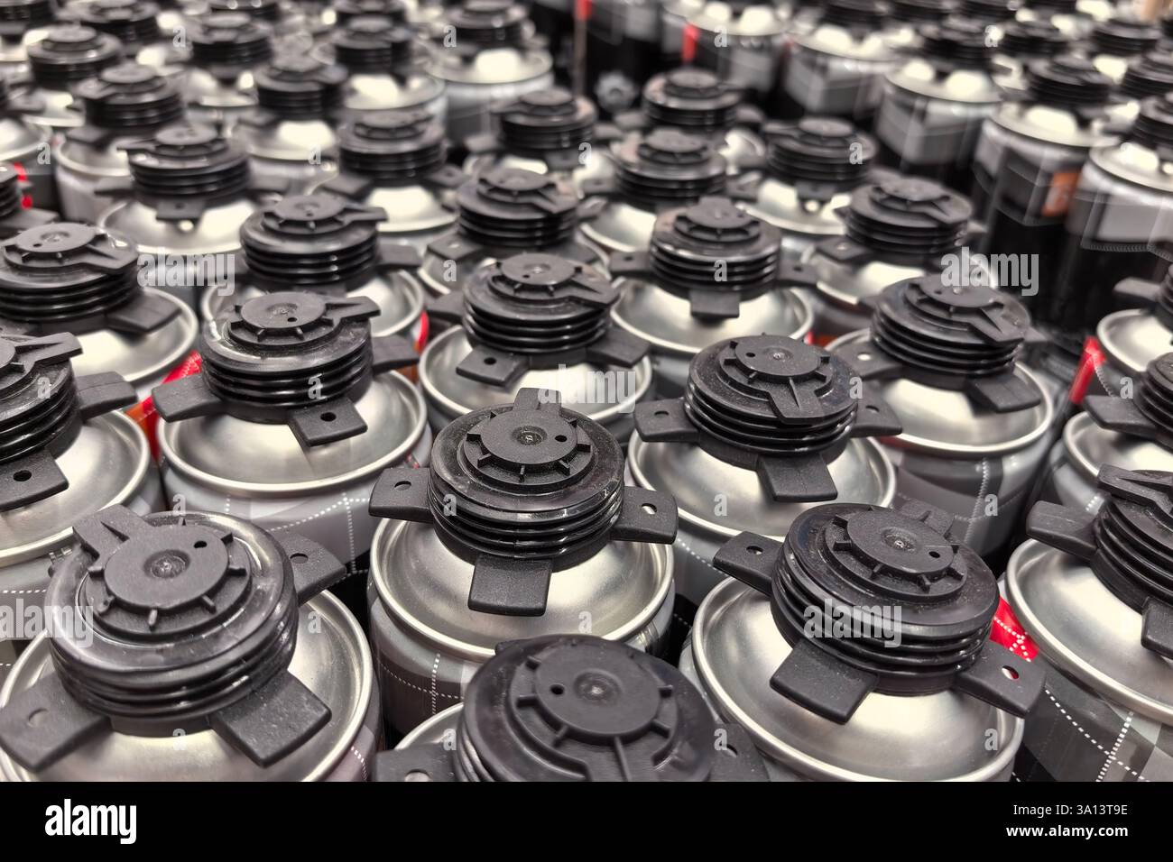 A multitude of spray paint cans in various colors are neatly arranged ...