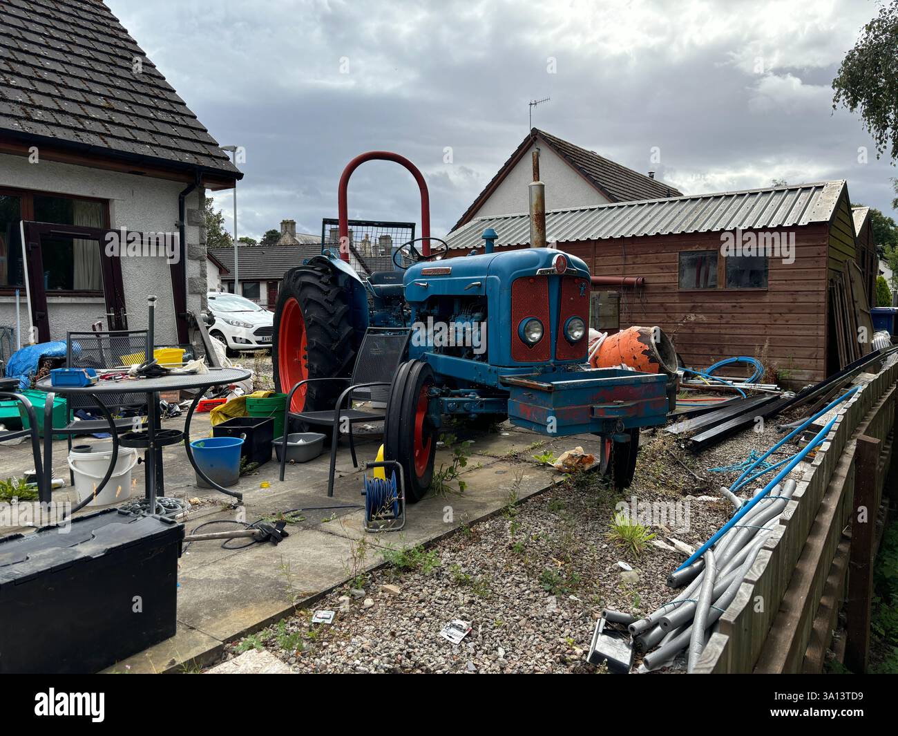 Vintage old tractors in a back garden. Farm machinery abandoned rusty - Smartphone Captured Stock Image
