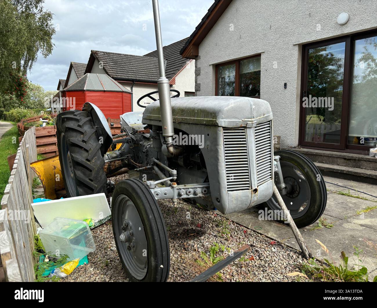 Vintage old tractors in a back garden. Farm machinery abandoned rusty - Smartphone Captured Stock Image
