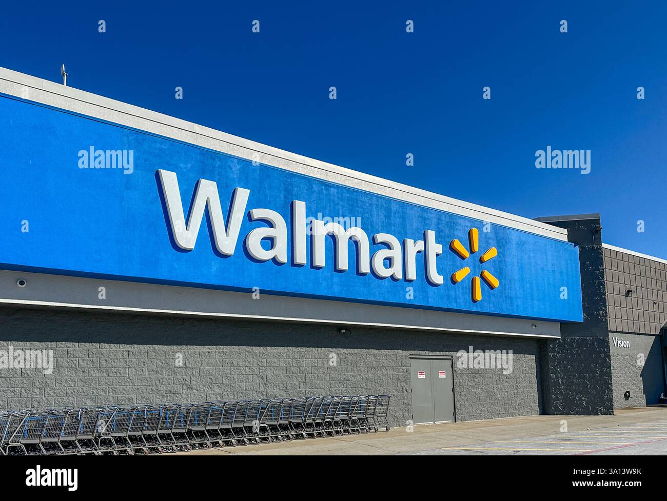 Walmart store sign and shopping carts against blue sky. Merrillville, IN USA March 6, 2025 - Smartphone Captured Stock Image