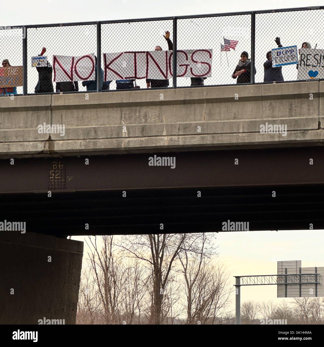 March 4, 2025. Protesters hold sings on a highway overpass at the No KIngs afternoon commute demonstration, Longmeadow, Massachusetts, United States, - Smartphone Captured Stock Image